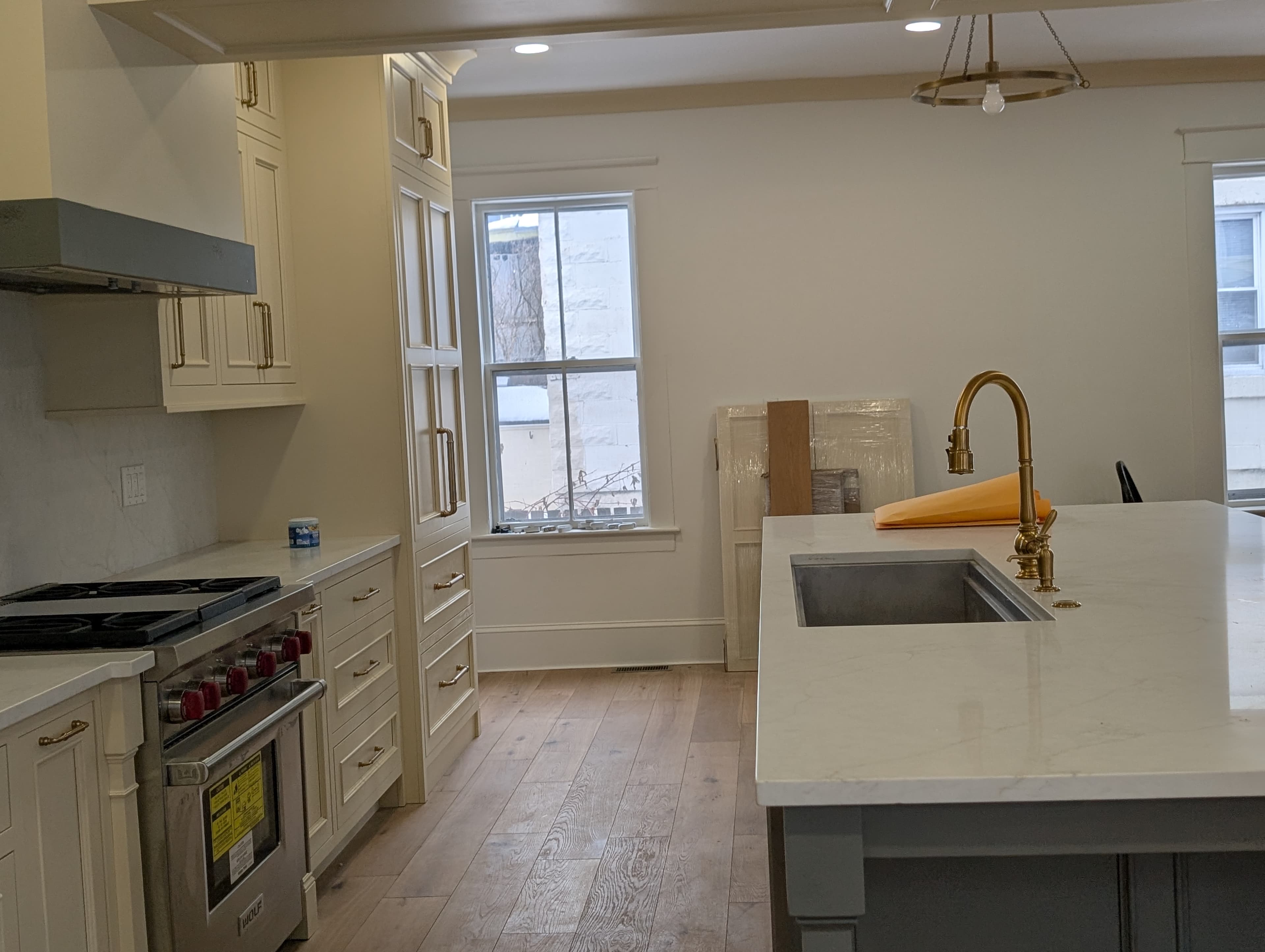 Finished kitchen remodel with custom cabinetry and marble island by Pro-Tech Contracting in Burlington Vermont